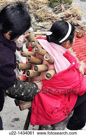 Yangshou China: a woman getting a Moxibustion treatment, a traditional Chinese medicine therapy with moxa mugwort herb, at the local market View Large Photo Image Stock Image - Yangshou China: a woman getting a Moxibustion treatment, a traditional Chinese medicine therapy with moxa mugwort herb, at the local market. Fotosearch