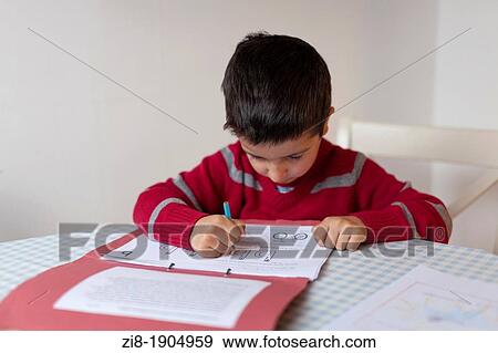 Stock Photo - Year one schoolboy, 5 learns to write the letters of the alphabet. Fotosearch