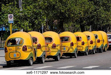 Stock Photo - Yellow cocotaxis in Havana, Coco taxis is a typical cheap taxi in Cuba. Fotosearch