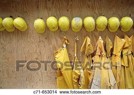 yellow construction hard hats and rain coats line up View Large Photo Image Picture - yellow construction hard hats and rain coats line up. Fotosearch