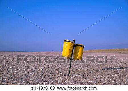 Stock Photo - yellow dustbin at empty beach in the Hague, the netherlands. Fotosearch
