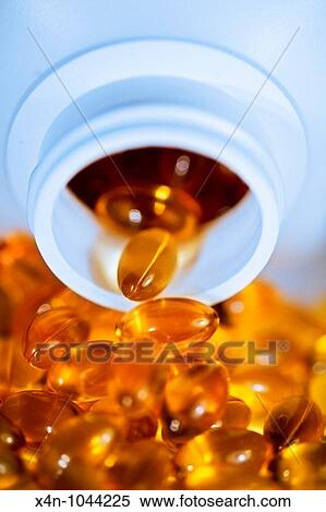 Yellow shiny pills spill out of bottle View Large Photo Image Stock Photography - Yellow shiny pills spill out of bottle. Fotosearch