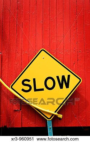 Yellow? slow? sign in front of bright red wooden wall View Large Photo Image Stock Image - Yellow? slow? sign in front of bright red wooden wall. Fotosearch