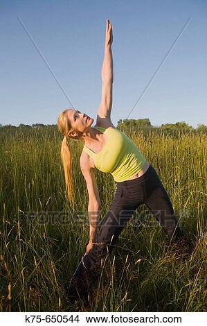 Picture - Yoga stretch outdoors. Fotosearch