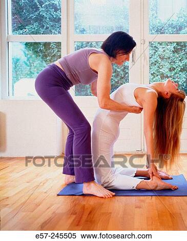 yoga teacher guiding student into challenging yoga posture. View Large Photo Image Stock Photography - yoga teacher guiding student into challenging yoga posture.. Fotosearch