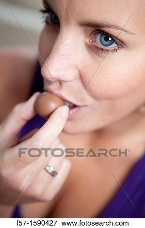 Youn woman eating chocolate View Large Photo Image Stock Photo - Youn woman eating chocolate. Fotosearch
