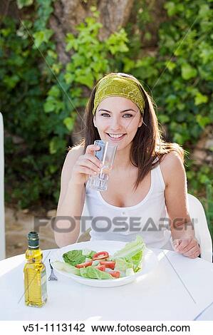 Youn woman enjoying a salad outdoor and drinking water View Large Photo Image Stock Image - Youn woman enjoying a salad outdoor and drinking water. Fotosearch