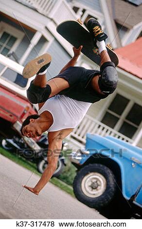 Young adult African american man balancing skateboard View Large Photo Image Stock Photo - Young adult African american man balancing skateboard. Fotosearch