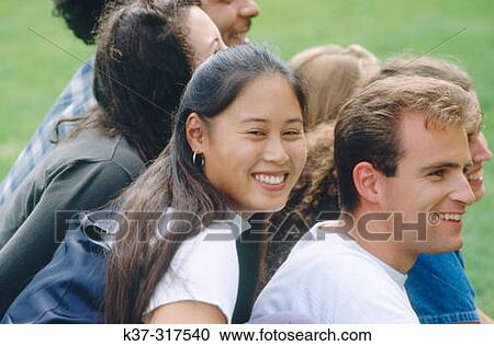 Young adult asian woman sitting with group of students on campus View Large Photo Image Stock Image - Young adult asian woman sitting with group of students on campus. Fotosearch