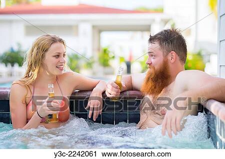 Young adult couple enjoying beer and talking in hot tub pool wellness area. View Large Photo Image Stock Image - Young adult couple enjoying beer and talking in hot tub pool wellness area.. Fotosearch