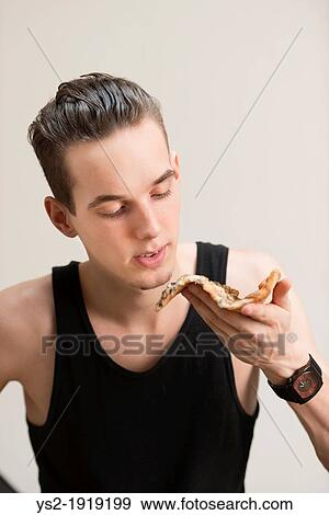 Young adult man wearing a black tank top and eating pizza View Large Photo Image Stock Photo - Young adult man wearing a black tank top and eating pizza. Fotosearch