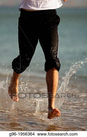 Young adult running at the beach. View Large Photo Image Picture - Young adult running at the beach.. Fotosearch