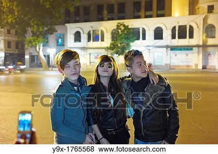 Young adults posing for pictures outside at night in Hanoi, Vietnam View Large Photo Image Stock Photo - Young adults posing for pictures outside at night in Hanoi, Vietnam. Fotosearch