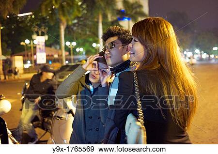Young adults posing for pictures outside at night in Hanoi, Vietnam View Large Photo Image Stock Photo - Young adults posing for pictures outside at night in Hanoi, Vietnam. Fotosearch
