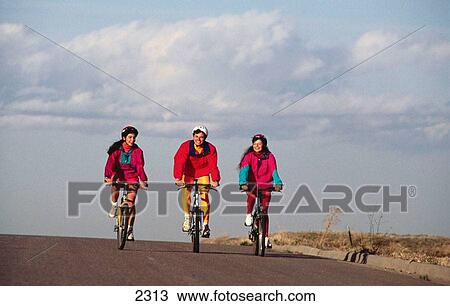 Stock Image - Young adults riding bikes. Fotosearch
