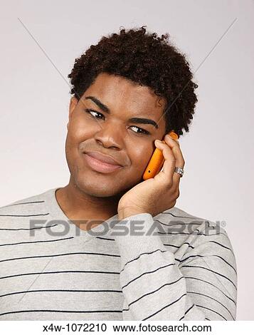 Stock Image - Young African-American man talking on cell phone. Fotosearch