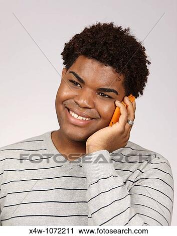 Stock Image - Young African-American man talking on cell phone. Fotosearch