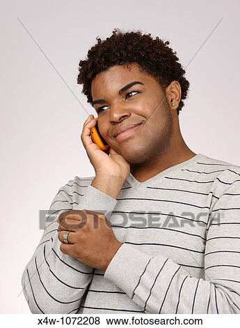 Young African-American man talking on cell phone View Large Photo Image Stock Photo - Young African-American man talking on cell phone. Fotosearch