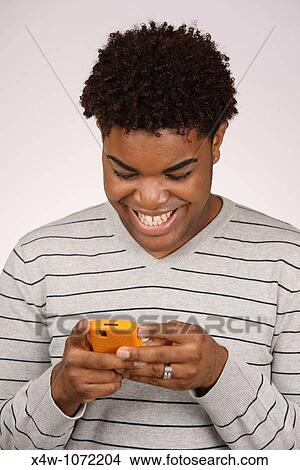 Young African-American man texting View Large Photo Image Picture - Young African-American man texting. Fotosearch