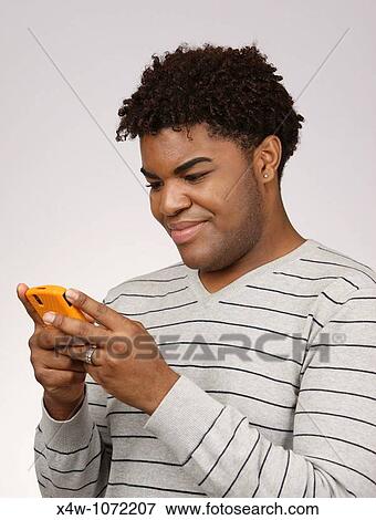 Young African-American man texting View Large Photo Image Stock Photo - Young African-American man texting. Fotosearch