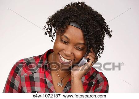 Stock Photo - Young African-American woman talking on cell phone. Fotosearch