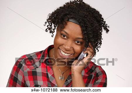 Stock Photo - Young African-American woman talking on cell phone. Fotosearch