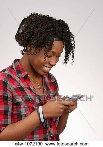 Young African-American woman texting View Large Photo Image Stock Image - Young African-American woman texting. Fotosearch