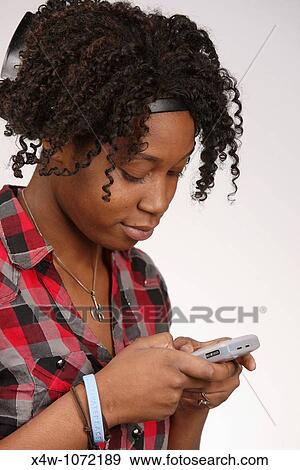 Young African-American woman texting View Large Photo Image Stock Photo - Young African-American woman texting. Fotosearch