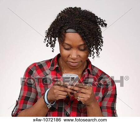 Stock Photograph - Young African-American woman texting. Fotosearch