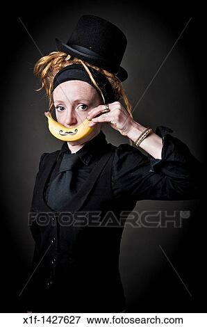 Young alt punky funky woman holding a banana with a moustache drawn on it over her mouth View Large Photo Image Stock Photo - Young alt punky funky woman holding a banana with a moustache drawn on it over her mouth. Fotosearch