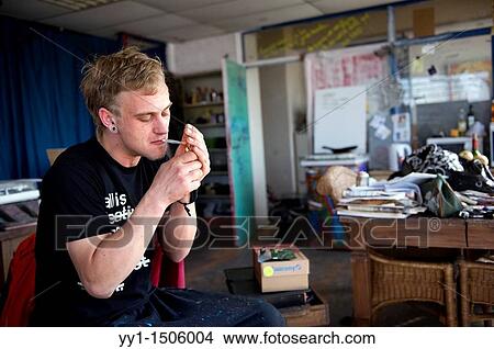 Young art-student, living in a squad, smoking a cigarette. View Large Photo Image Picture - Young art-student, living in a squad, smoking a cigarette.. Fotosearch