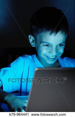 Young Asian boy using laptop at night. View Large Photo Image Stock Image - Young Asian boy using laptop at night.. Fotosearch