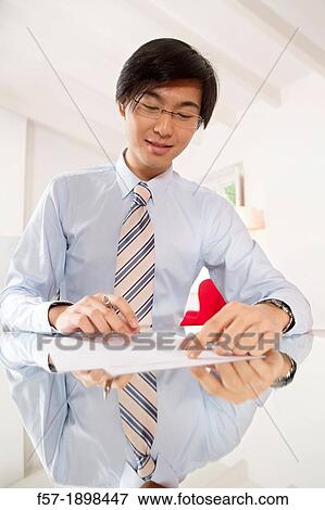 Young Asian businessman signing contracts View Large Photo Image Stock Photo - Young Asian businessman signing contracts. Fotosearch