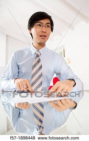 Young Asian businessman signing contracts View Large Photo Image Stock Photo - Young Asian businessman signing contracts. Fotosearch