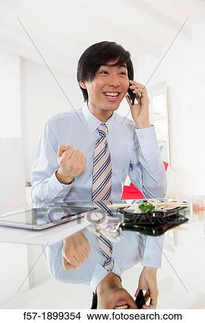 Young Asian businessman talking on his smartphone View Large Photo Image Picture - Young Asian businessman talking on his smartphone. Fotosearch