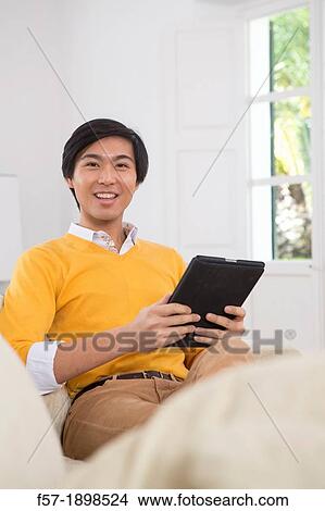 Young Asian businessman using his Tablet computer View Large Photo Image Picture - Young Asian businessman using his Tablet computer. Fotosearch