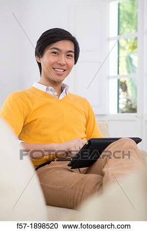 Young Asian businessman using his Tablet computer View Large Photo Image Stock Image - Young Asian businessman using his Tablet computer. Fotosearch