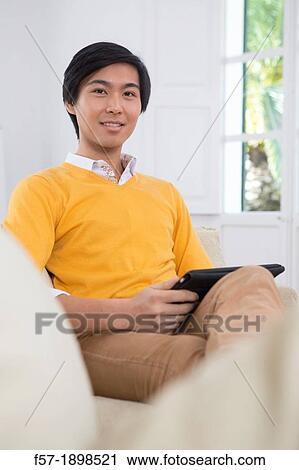 Young Asian businessman using his Tablet computer View Large Photo Image Stock Image - Young Asian businessman using his Tablet computer. Fotosearch