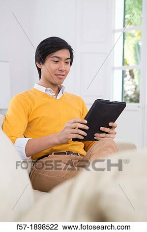 Young Asian businessman using his Tablet computer View Large Photo Image Stock Image - Young Asian businessman using his Tablet computer. Fotosearch