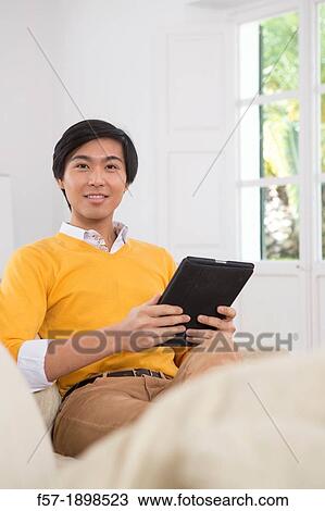 Young Asian businessman using his Tablet computer View Large Photo Image Stock Image - Young Asian businessman using his Tablet computer. Fotosearch