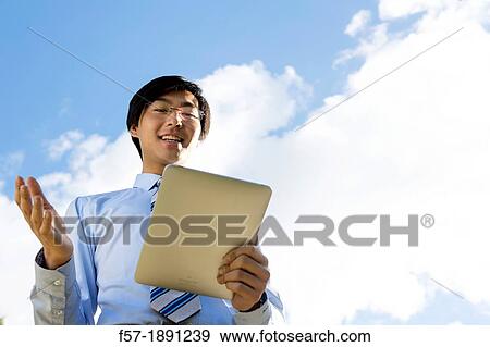 Young Asian businessman using his Tablet computer View Large Photo Image Stock Photo - Young Asian businessman using his Tablet computer. Fotosearch
