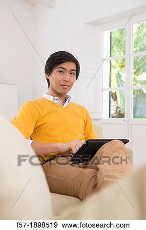 Young Asian businessman using his Tablet computer View Large Photo Image Stock Photo - Young Asian businessman using his Tablet computer. Fotosearch