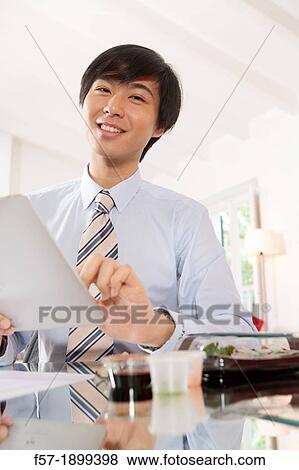 Young Asian businessman using his Tablet computer View Large Photo Image Stock Photo - Young Asian businessman using his Tablet computer. Fotosearch