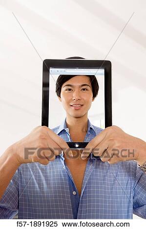Stock Photography - Young Asian businessman using his Tablet computer. Fotosearch