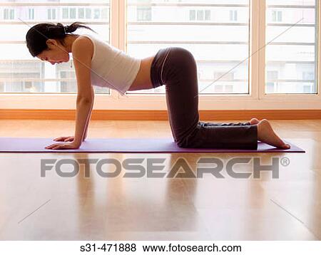 Stock Photo - young asian girl practicing yoga at home. Fotosearch