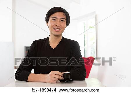 Young Asian man drinking expresso coffee View Large Photo Image Picture - Young Asian man drinking expresso coffee. Fotosearch