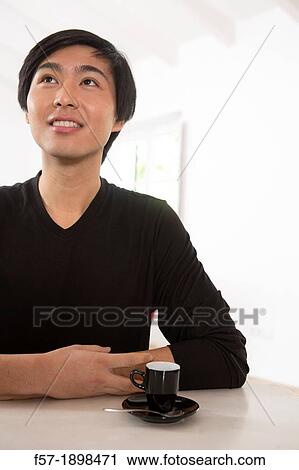 Young Asian man drinking expresso coffee View Large Photo Image Stock Image - Young Asian man drinking expresso coffee. Fotosearch