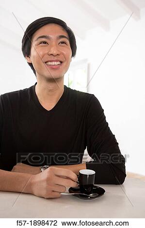 Young Asian man drinking expresso coffee View Large Photo Image Stock Image - Young Asian man drinking expresso coffee. Fotosearch