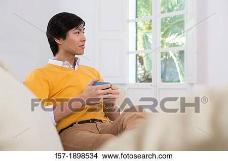 Young Asian man drinking tea View Large Photo Image Picture - Young Asian man drinking tea. Fotosearch