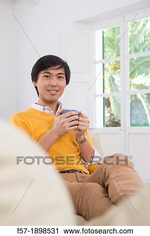 Young Asian man drinking tea View Large Photo Image Stock Image - Young Asian man drinking tea. Fotosearch